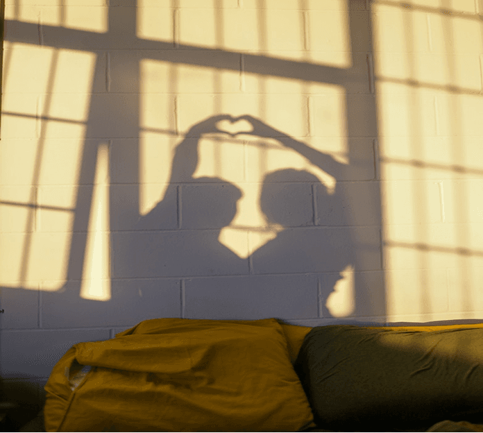 Shadow of a couple making a heart shape with their hands